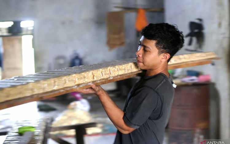 Pekerja menyelesaikan pembuatan tempe di kelurahan Bojongsari, Indramayu, Jawa Barat, Selasa (24/1/2023). Pemerintah menargetkan penyaluran Kredit Usaha Rakyat (KUR) pada Tahun 2023 sebesar Rp460 triliun atau jumlah ini naik 23,32 persen dari tahun 2022 yang sebesar Rp373 triliun. (ANTARA FOTO/Dedhez Anggara/hp)
