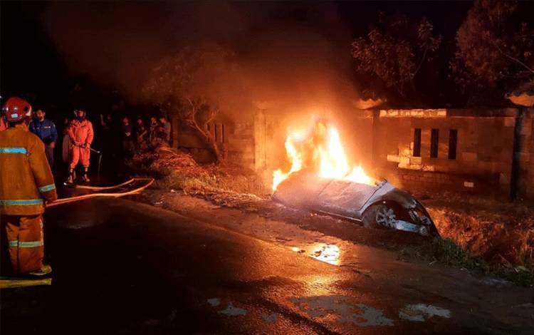 Petugas pemadam kebakaran saat mengevakuasi mobil yang terbakar di Jalan Tjilik Riwut, Kamis, 27 April 2023.(FOTO: IST)