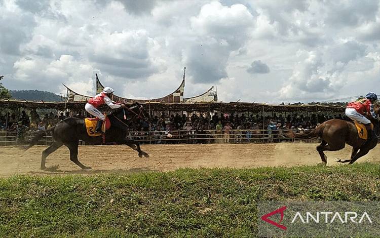 Dua orang joki memacu kuda di arena pacuan kuda Bukit Gombak Kabupaten Tanah Datar, Minggu, (30/4). ANTARA/Muhammad Zulfikar.
