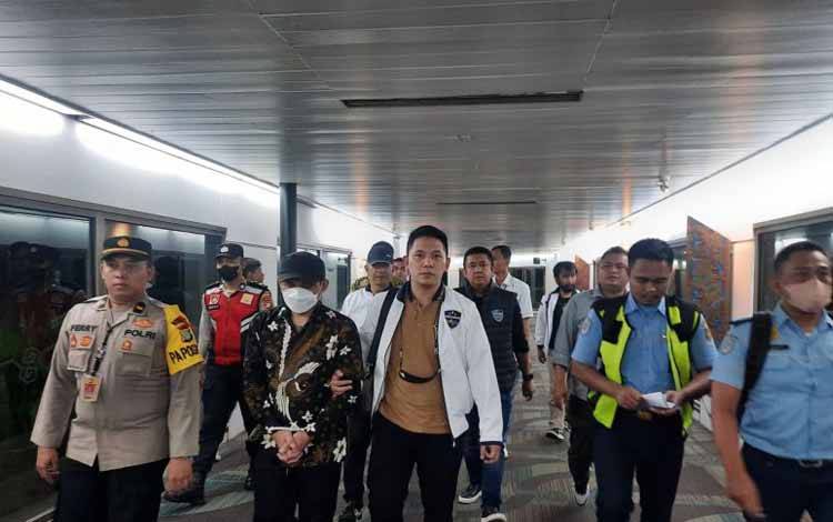 AP Hasanuddin berpakaian batik dengan tangan diborgol dibawa penyidik keluar dari ruangan Bandara Soekarno-Hatta menuju Bareskrim Polri untuk menjalani pemeriksaan sebagai tersangka dugaan ujaran kebencian terkait warga Muhammadiyah, Minggu (30/4/2023). (ANTARA/HO-Divisi Humas Polri)