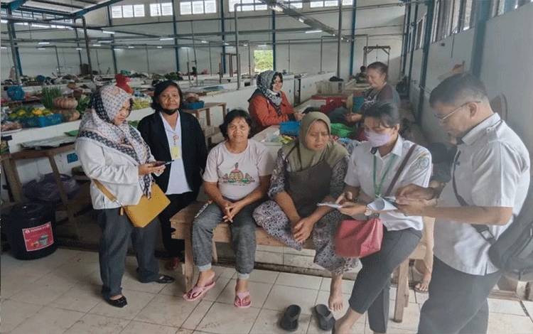Sejumlah pegawai DPMPTSP Kabupaten Lamandau sosialisasi terkait Nomor Induk Usaha kepada pedagang di Pasar Induk Nanga Bulik. (FOTO : HENDI NURFALAH)