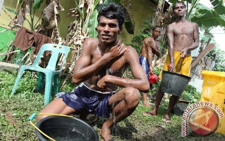 Imigran Rohingnya dan Bangladesh Imigran etnis Rohingya mandi di lokasi penampungan sementara, Pangkalan Susu, Langkat, Sumatera Utara, Minggu (17/5/15). Sebanyak 53 imigran asal Bangladesh dan 43 imigran etnis Rohingya, Myanmar, berada di lokasi penampungan tersebut setelah diselamatkan pada Jumat (15/5/15). (ANTARA FOTO/Irsan Mulyadi)
