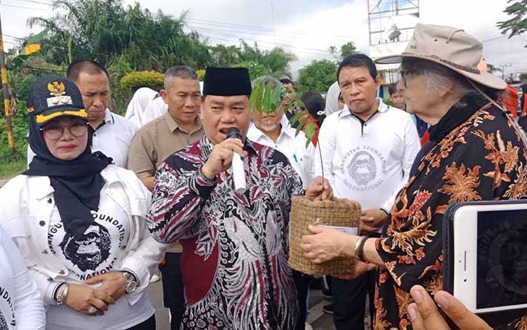 Bupati Kotawaringin Timur menerima pohon penghijau secara simbolis dari Direktur Yayasan OFI Birute M.F. Galdikas saat memperingati Hardiknas, Minggu, 14 Mei 2023. (FOTO: DEWIP) 