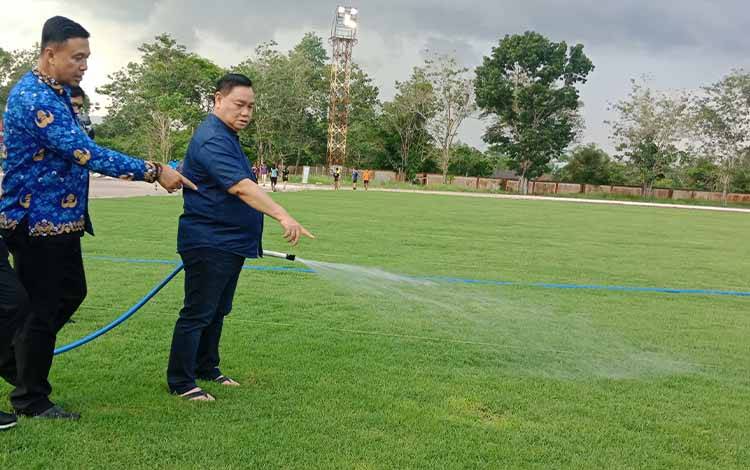 Bupati Kotawaringin Timur Halikinnor menyiram rumput lapangan sepak bola di Stadion 29 November Sampit, Rabu, 17 Mei 2023. (FOTO: DEWIP)