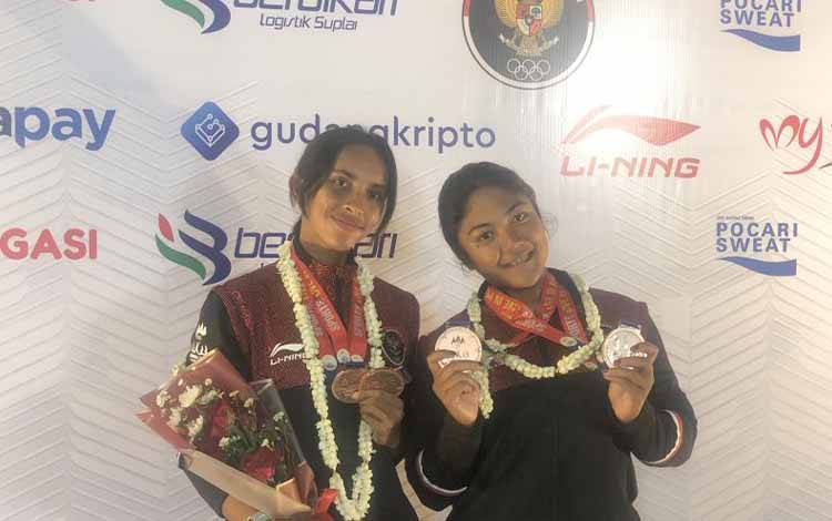 Fitriani Nadea Putri (kiri) dan Cinta Priendtisca Nayomi (kanan) berpose memamerkan medali yang didapat di SEA Games 2023 Kamboja cabang olahraga Traditional Boat Race (TBR). (ANTARA/Zaro Ezza Syachniar)