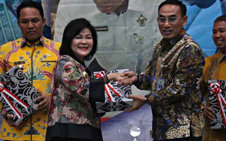 Bupati Pulang Pisau Pudjirustaty Narang saat menerima opini WTP untuk kedelapan kalinya yang diserahkan oleh Kepala BPK RI perwakilan Kalimantan Tengah, M Ali Asyhar. (FOTO: IST)