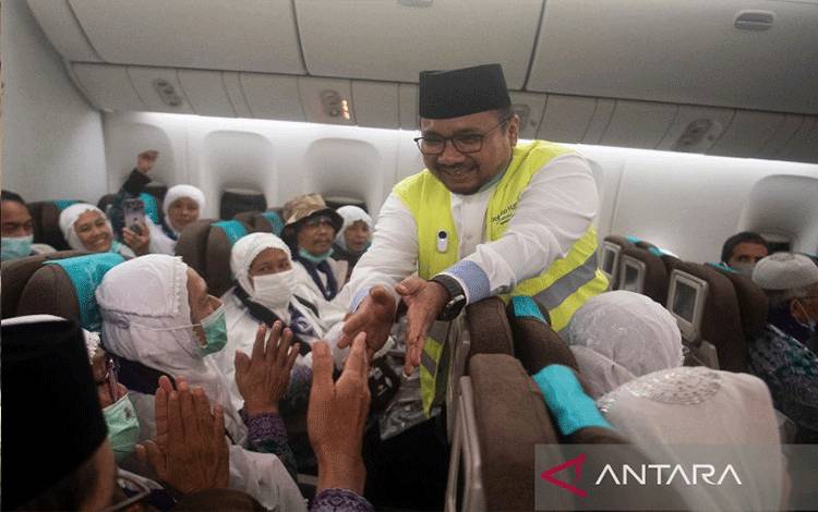Menteri Agama Yaqut Cholil Qoumas menyapa peserta ibadah haji di dalam pesawat sebelum terbang ke Madinah, Rabu (24/5/2023). (ANTARAFOTO/Wahyu Putro)