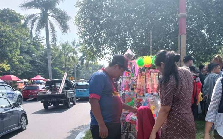 Pedagang mainan Yuda (Kiri) saat melayani pembeli di Festival Budaya Isen Mulang, Rabu, 24 Mei 2023.