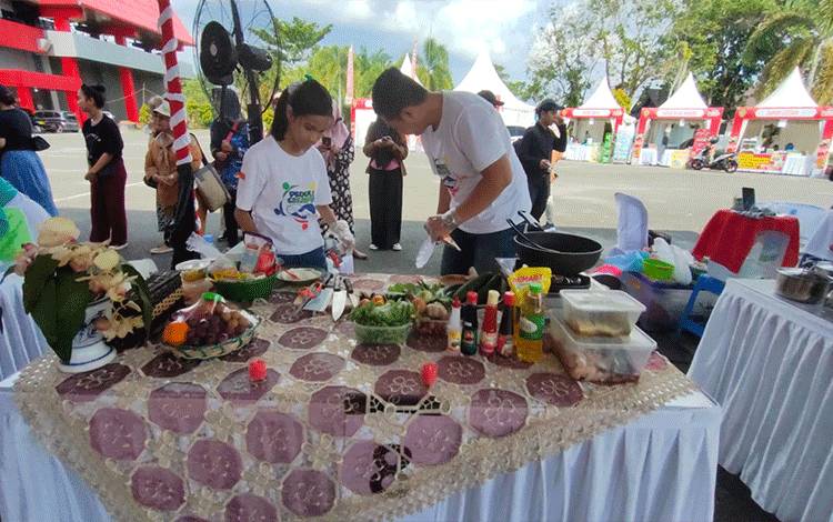 Salah satu peserta sedang memasak masakan berbahan ikan patin di Halaman Stadion Tuah Pahoe Palangka Raya. (FOTO: IST)