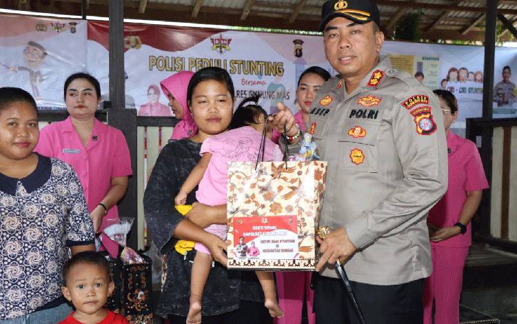 Kapolres Gunung Mas AKBP Asep Bang bang Saputra saat menyerahkan bantuan sosial kepada keluarga yang memiliki anak dengan gangguan gizi di Kecamatan Rungan, Kamis, 25 Mei 2023. (FOTO: HUMAS POLRES GUNUNG MAS)