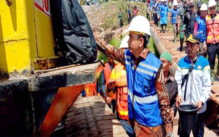 Bupati Barito Utara H Nadalsyah melakukan prosesi tapung tawar sebelum para pekerja melakukan pekerjaan, pemancangan lanjutan pembangunan jembatan Sikan-Tumpung Laung.(foto: Dhani)