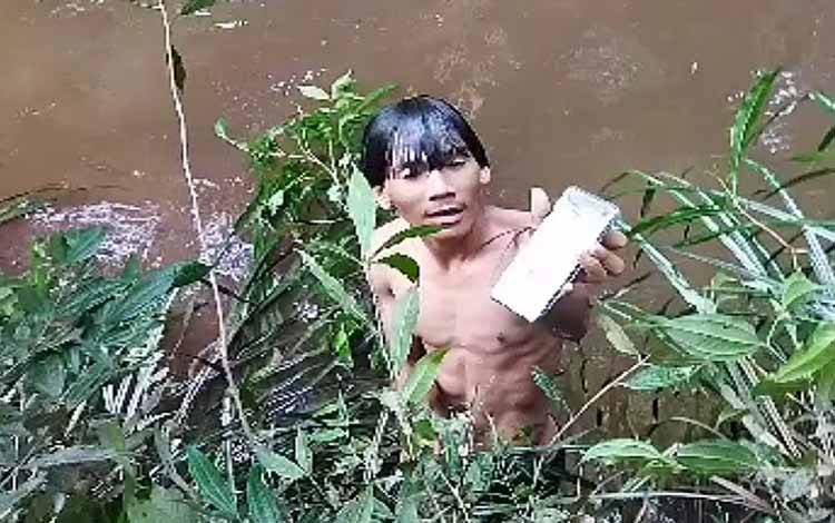 Relawan Matabu Jaya menemukan HP milik Dermarius (20) di Sungai Sirau tidak jauh dari tempat ditemukan rokok dan charger. (Foto: TANGKAPAN LAYAR VIDEO)