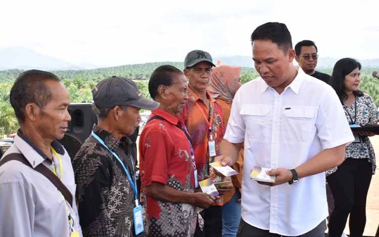 Bupati Lamandau Hendra Lesmana menyerahkan buku rekening BPR Lingga Sejahtera kepada sejumlah anggota Koperasi Karya Bakti Mitra Bakuba.