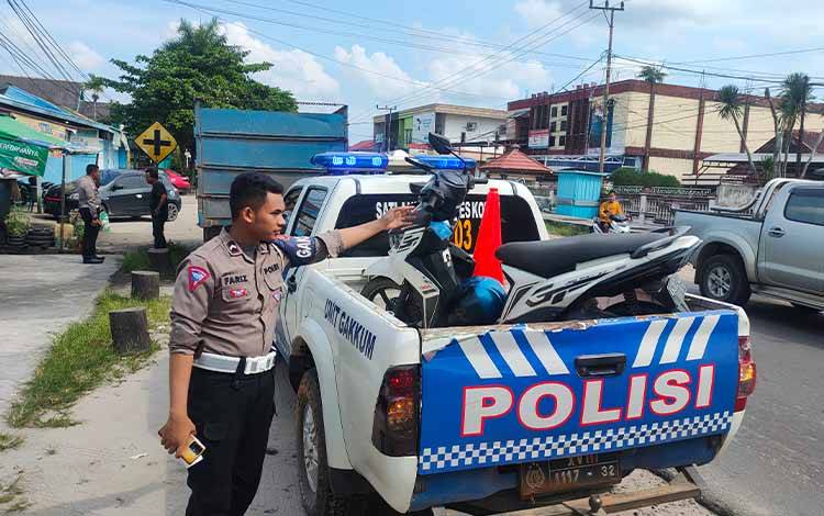 Anggota Satlantas Polres Kotim saat mengamankan sepeda motor yang terlibat kecelakaan di Jalan Kapten Mulyono, Sampit. (FOTO: BUDDI)