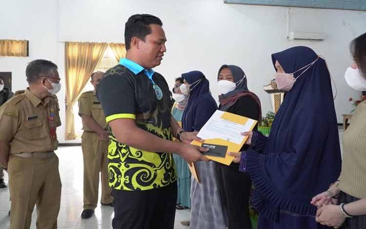 Bupati Hendra Lesmana menyerahkan Nomor Induk Berusaha (NIB) kepada salah satu pelaku UMKM di Kabupaten Lamandau. (FOTO : HENDI NURFALAH)
