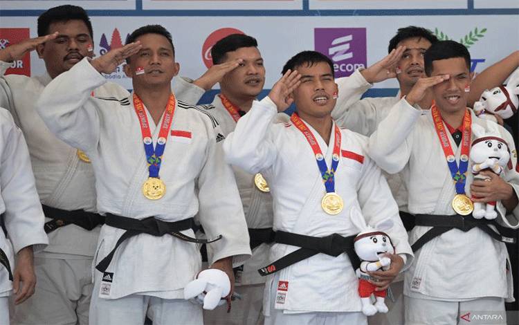 Tim beregu judoka tunanetra Indonesia yang mengenakan medali emas memberi hormat ke bendera Merah Putih saat upacara penghargaan pemenang usai final judo tunanetra putra beregu ASEAN Para Games 2023 di Youth Federation Hall, Phnom Penh, Kamboja, Selasa (6/6/2023). . ANTARA FOTO/Zabur Karuru/aww.