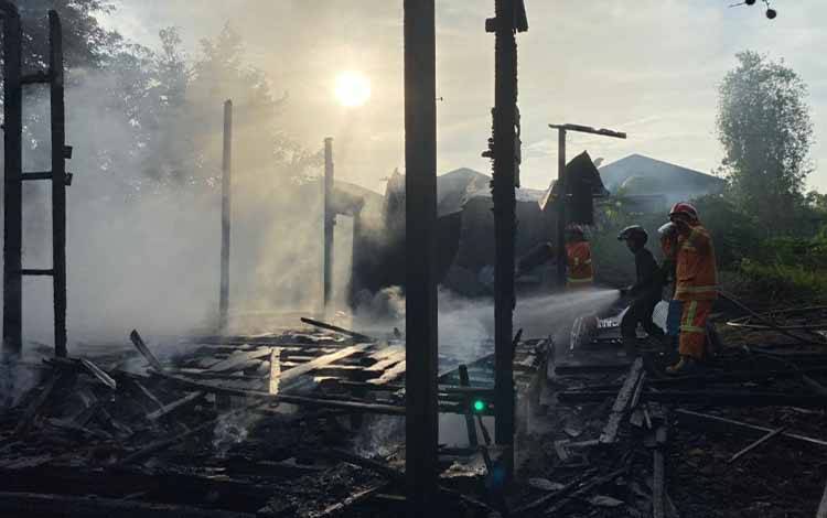 Petugas pemadam kebakaran saat memadamkan api di rumah yang tidak berpenghuni di Jalan Jenderal Sudirman, Gang, SMA PGRI, Sampit. (FOTO: IST)
