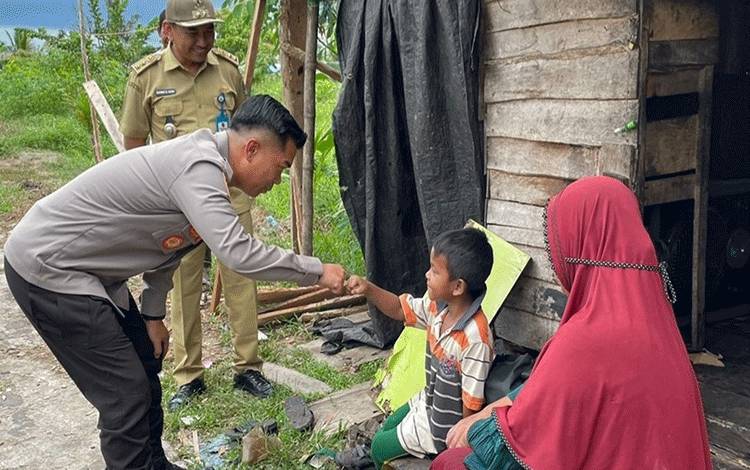 Kapolres Kapuas AKBP Kurniawan Hartono saat menyambangi warga berbagi bantuan sembako di Kelurahan Selat Utara. (FOTO: IST)