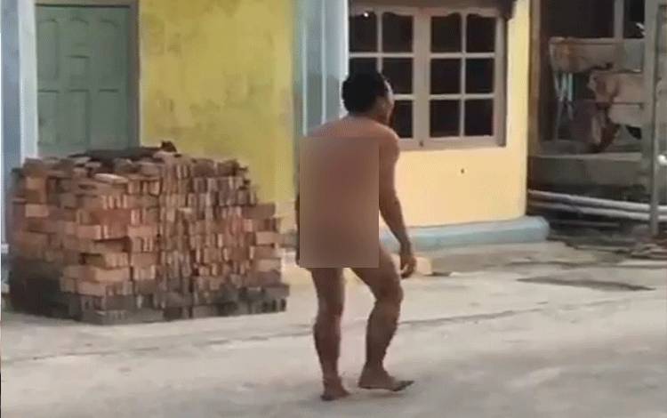 Pria yang diduga ODGJ berjalan tanpa menggunakan pakaian di sekitar jalan yang ada di Kota Sampit. (FOTO: IST)