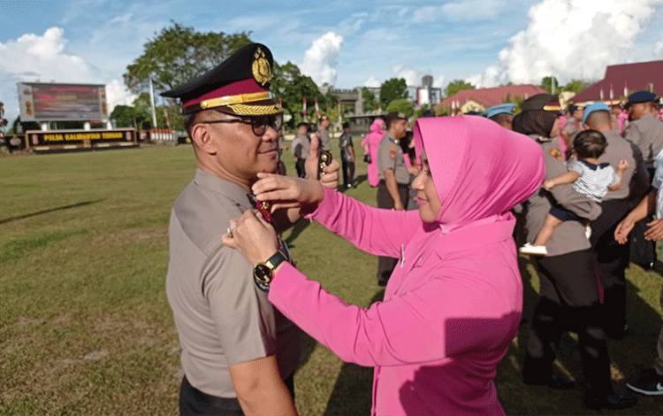 Kabid Humas Polda Kalteng, Kombes Pol Erlan Munaji, saat dilakukan pemasangan pangkat baru oleh istrinya (Foto : IST)