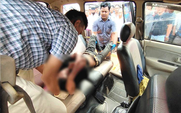 Anggota Satreskrim Polres Barito Utara mengangkat jasad korban keracunan AC dalam mobil di Water Front City Muara Teweh, Kamis 6 Juli 2023. (Foto: Dhani)