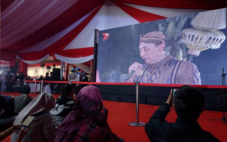 Warga mengabadikan momen Kapolri Jenderal Pol. Listyo Sigit Prabowo bernyanyi di acara pagelaran wayang kulit lakon Wahyu Cakranigrat dalam rangka HUT ke-77 Bhayakara di Lapangan Bhayangkara, Jakarta, Jumat malam (7/7/2023). ANTARA/Laily Rahmawaty.