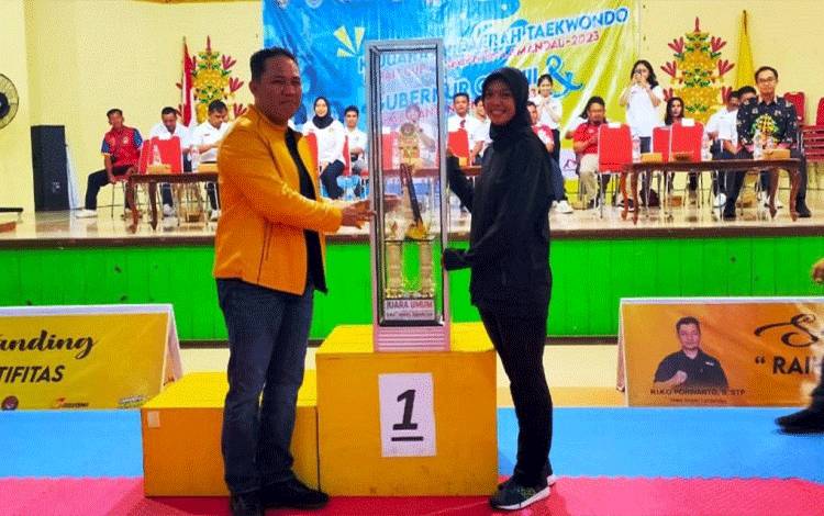 Bupati Lamandau Hendra Lesmana menyerahkan Piala bergilir Kejurda Taekwondo se Kalteng kepada ketua kontingen Kabupaten Katingan. (FOTO : HENDI NURFALAH)