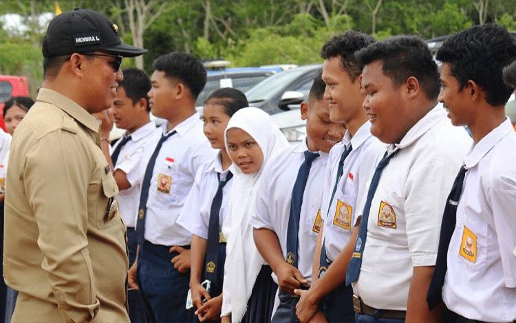 Disela melaksanakan kunjungan kerja, Bupati Lamandau Hendra Lesmana menyapa sejumlah pelajar SMPN 1 Belantikan Raya. (FOTO : HENDI NURFALAH)