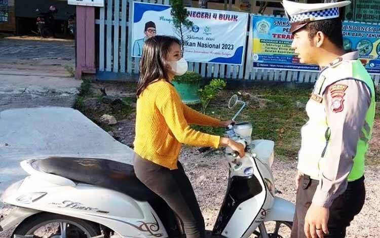 Anggota Satlantas Polres Lamandau tengah menghentikan salah satu pemotor yang tidak menggunakan helm saat berkendara. (FOTO: HENDI NURFALAH)