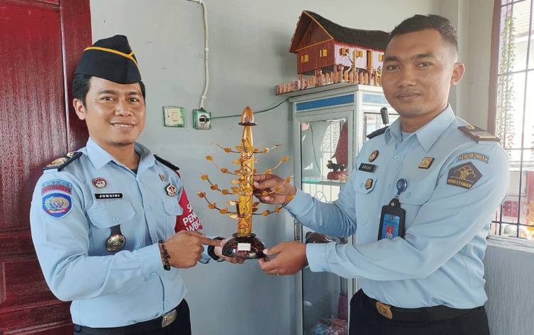 Kasubsi Pelayanan Tahanan Rutan Tamiang Layang, Junaidi (kiri) memamerkan miniatur Tugu Gunung Perak karya warga binaan pemasyarakatan, Selasa, 11 Juli 2023. (FOTO: BOLE MALO)