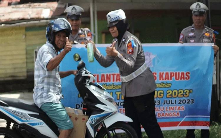 Personel Satlantas Polres Kapuas saat beri reward pengguna jalan tertib berlalu lintas di Kota Kuala Kapuas. (FOTO: IST)