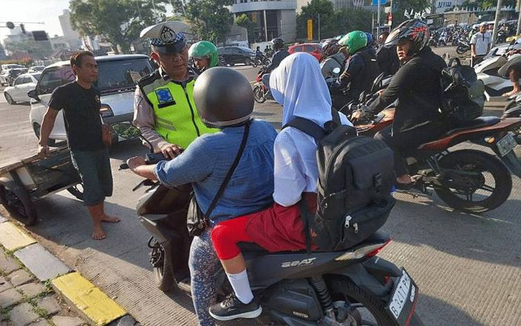 Seorang anggota Satlantas Jakarta Pusat melakukan penindakan terhadap seorang pengendara sepeda motor yang tidak menggunakan helm di Jembatan Besi, Jakarta Pusat, Selasa (11/7/2023) (ANTARA/HO-Ditlantas Polda Metro Jaya)