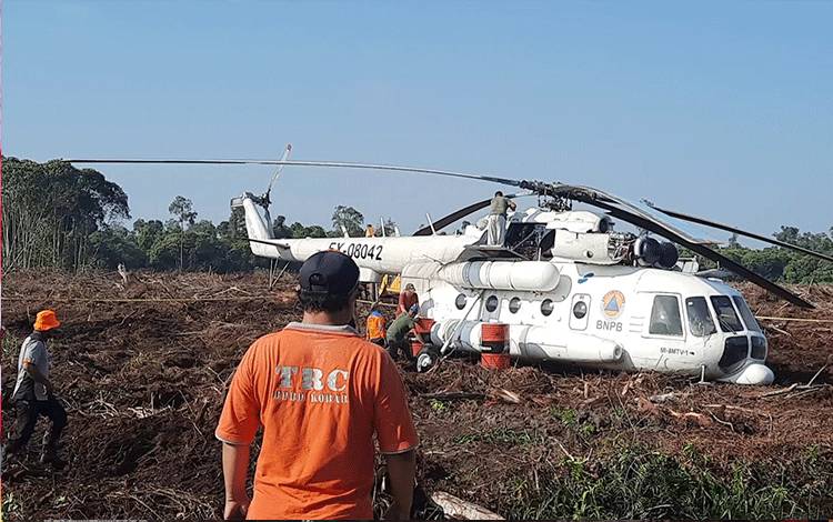 Tim Reaksi Cepat (TRC) BPBD Kobar turun memberikan bantuan logistik dalam upaya evakuasi Helikopter yang mendarat darurat di Mendawai Seberang. (Foto : DANANG)