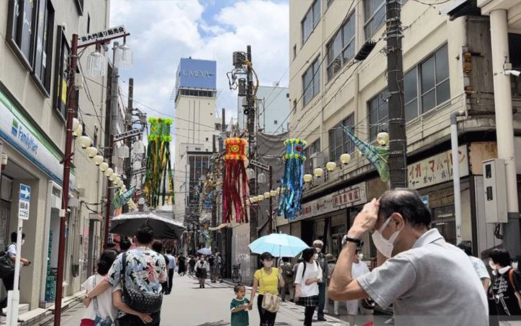 Warga melindungi diri dari cuaca panas dengan payung dan telapak tangan saat Festival Tanabata, Hiratsuka di Jepang, Minggu (9/7/2023). (ANTARA/ Juwita Trisna Rahayu)