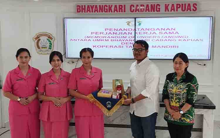 Bhayangkari Cabang Kapuas, Prietha Perthantri Kurniawan menyerahkan secara simbolis produk UMKM kepada Pengurus Koperasi Taraku Mandiri, Senin sore, 7 Agustus 2023. (FOTO: DODI)