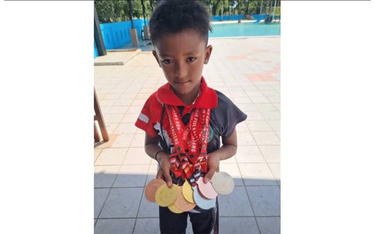 Atlet renang jenjang SD asal Kotawaringin Timur memperlihatkan perolehan medali. (FOTO: IST)