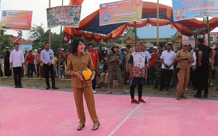 Bupati Pulang Pisau, Pudjirustaty Narang saat melakukan servis perdana sebagai tanda dibukanya turnamen bola Volly di Kecamatan Maliku. Senin, 14 Agustus 2023. ( FOTO : M PRADILA KANDI )