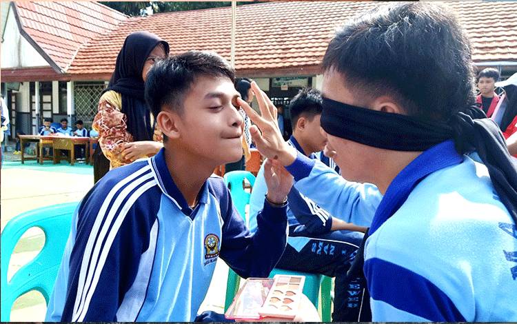 Siswa SMAN 1 Muara Teweh saat melaksanakan lomba merias wajah teman dengan mata ditutup dengan kain. Lomba ini dalam rangka memperingati HUT Kemerdekaan ke 78 RI, dihalaman SMAN 1, Rabu 16 Agustus 2023. (Foto: Dhani)