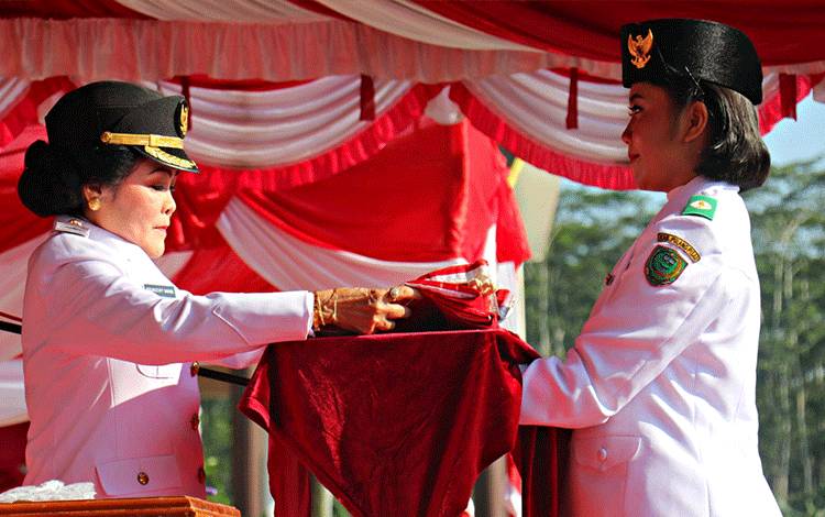 Bupati Pulang Pisau, Pudjirustaty Narang saat menyerahkan bendera pusaka merah putih kepada anggota Paskibraka. Kamis, 17 agustus 2023. ( FOTO : M PRADILA KANDI )
