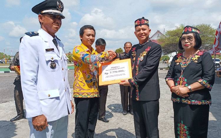 Bupati Gunung Mas Jaya S Monong saat menyerahkan piagam penghargaan kepada pemenang juara pertama lomba desa tingkat Kabupaten Gunung Mas tahun 2023, Kamis, 17 Agustus 2023. (FOTO: RISKA YULYANA)