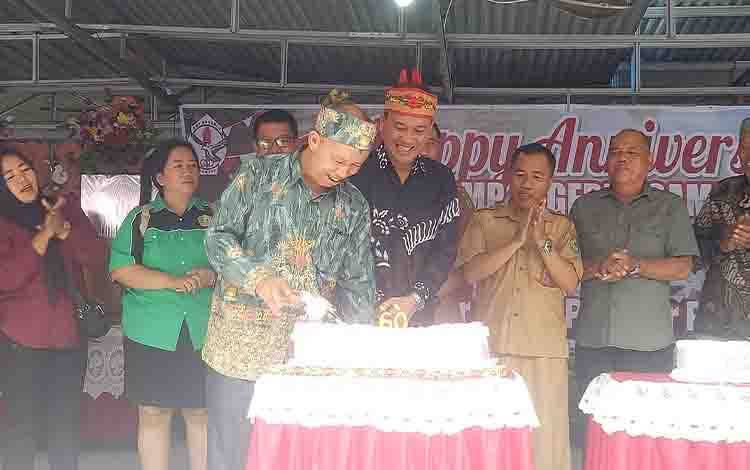 Kepsek SMPN 2 Sampit Abdurrahman saat memotong kue ulang tahun SMPN 2 Sampit didampingi para tamu undangan, Selasa, 22 Agustus 2023. (FOTO: NISA)