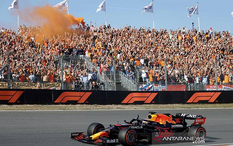 Arsip - Pendukung Orange Army bergembira saat pebalap F1 Red Bull, Max Verstappen melakukan lintatasan selebrai usai menjuarai balapan di sirkuit Zandvoort, Belanda (5/9/2021). ANTARA/AFP/Kenzo Tribouillard/aa.