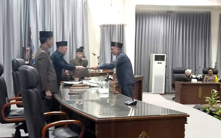 Anggota DPRD Fraksi Partai Gerindra, Mustafa Joyo Muhtar menyerahkan pemandangan umum fraksi terkait raperda APBD Perubahan tahun anggaran 2023 kepada pimpinan rapat paripurna, di gedung DPRD setempat. (FOTO: DHANI)