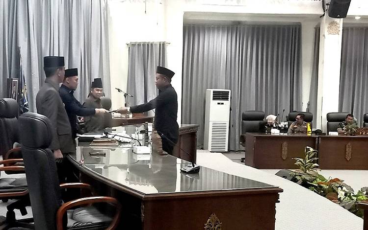 Anggota Fraksi PPP DPRD Barito Utara, Nuryanto menyerahkan pemandangan umum fraksi terkait raperda Perubahan APBD 2023 kepada pimpinan rapat paripurna, di gedung DPRD setempat. (FOTO: DHANI)