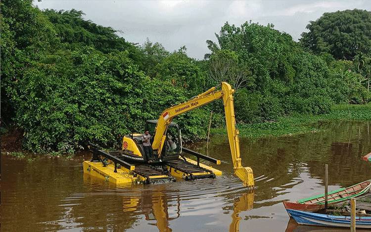 Uji coba pertama ekskavator amfibi di sungai Pamuatan, Sampit. (FOTO: DEWIP)
