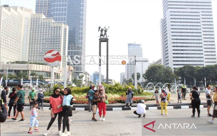 Warga berpose untuk foto di depan Bundaran HI, Jakarta, Minggu (10/9/2023). (ANTARA/Nadia Putri Rahmani)