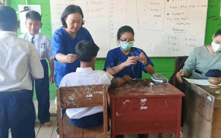 Tenaga Kesehatan UPT BLUD Puskesmas Pahandut saat memeriksa kesehatan murid SMPN Satu Atap 8 Palangka Raya (Foto : Pathur)