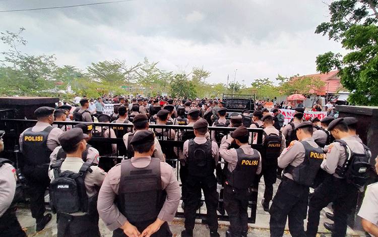 Aksi damai oleh puluhan masyarakat di halaman Pengadilan Tipikor Palangka Raya dikawal oleh pihak kepolisian, Selasa, 12 September 2023. (FOTO: APRI)