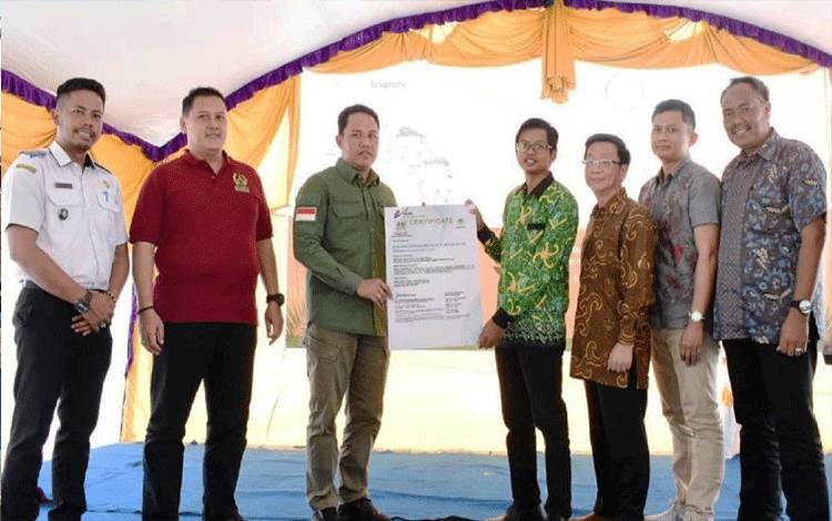 Bupati Lamandau Hendra Lesmana secara simbolis menyerahkan sertifikat RSPO kepada Direktur dan Manager ICS BUMDes Berkah Mulya Jaya, Choirul Fuadi. (FOTO : HENDI NURFALAH)