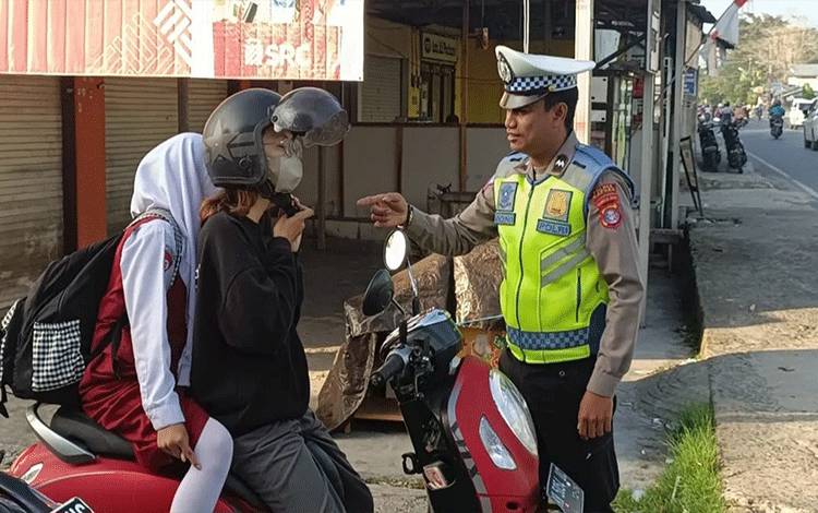 Personel Satlantas Polres Kapuas saat berikan edukasi pengendara selalu klik helm, Jumat, 15 September 2023. (FOTO: IST)
